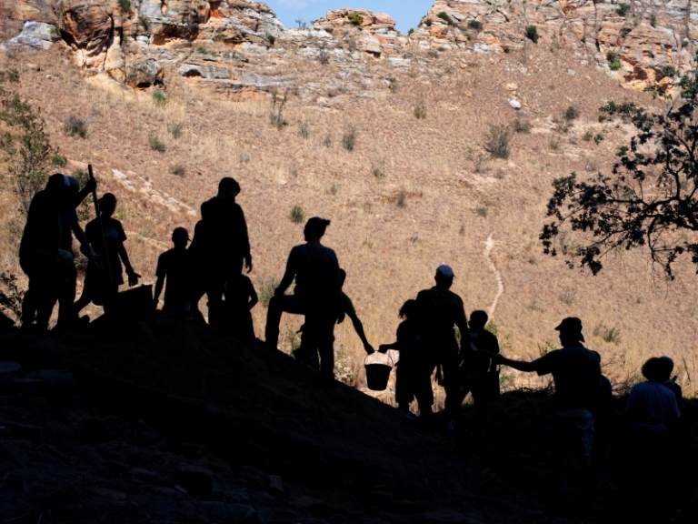 human silhouettes in front of a mountain